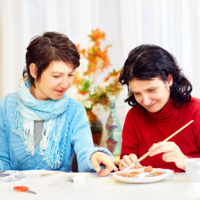 mother teaching to her daughter to paint
